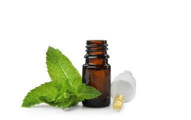 Bottle of essential oil and mint on white background