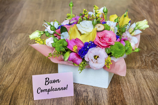 Flower Box of Colorful Roses,Freesia and Greenery with Buon Compleanno Text in Italian  which Means Happy Birthday 