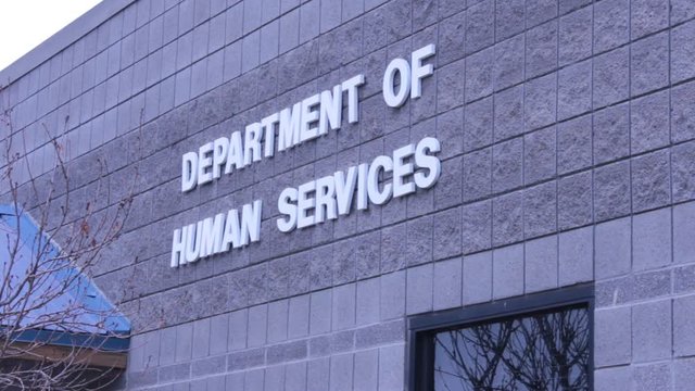 White lettering sign on a brick wall that reads Department of Human Services.