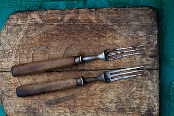 Old beautiful vintage forks on wooden cutting Board