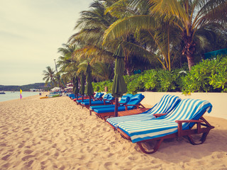 Obraz na płótnie Canvas Umbrella and chair on the tropical beach sea and ocean at sunrise time