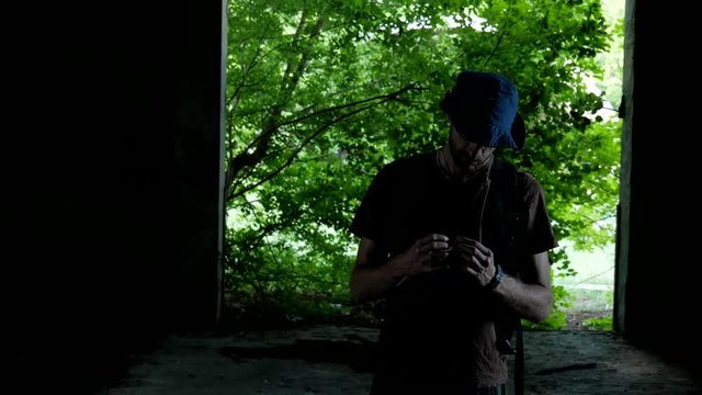 Tourist walks in dark abandoned garage found in the deep forest