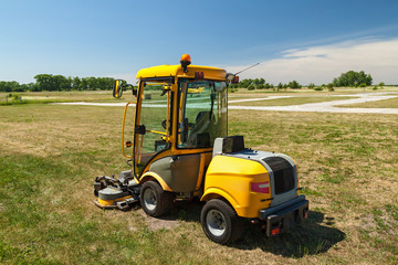 Large yellow machine for cutting grass with large windows