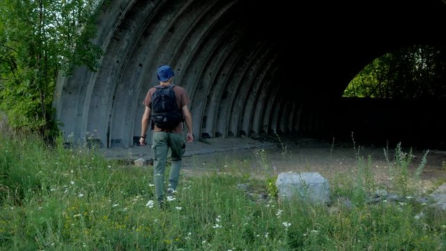 Ranger walks to the big hangar in the forest at abandoned military base