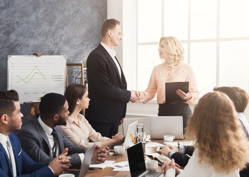 Boss handshaking employee congratulating with promotion