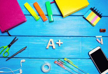 school supplies in the school desk, stationery, school concept, blue background, creative chaos, space for text, markers, pens, notepads, stickers. highest mark. good grade in school. 
