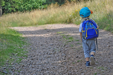 Little boy with a backpack wanders with a backpack in the mountains, Poland, Sudety Mountains