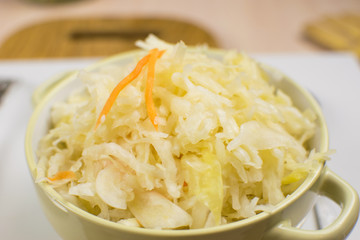 Sauerkraut in a bowl on a light background.