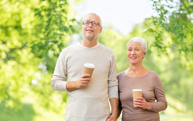 old age and people concept - happy senior couple with coffee cups over green natural background