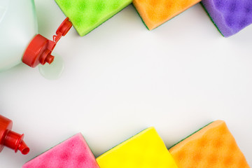 Multicolored foam rubber sponges and detergent on a light background.