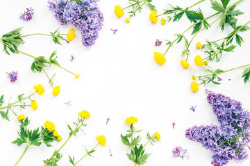 Lilac and yellow flowers on white background. Flat lay, top view