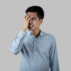 Portrait stressed and anxiety handsome young asian man wearing a blue shirt isolated on gray wall background.  Asia people.