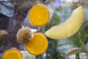Fototapeta na wymiar Obst, welches in einen Eisblock eingefroren ist