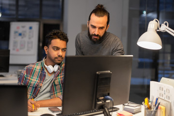 deadline, technology and people concept - creative team with computers working together late at...