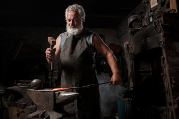 Blacksmith with brush handles the molten metal