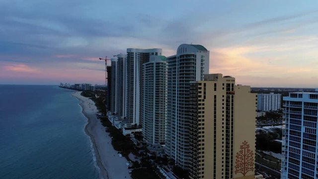 Cinematic aerial view of Sunny Isles beach at sunset in Miami, Florida, USA