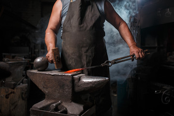 Blacksmith with brush handles the molten metal