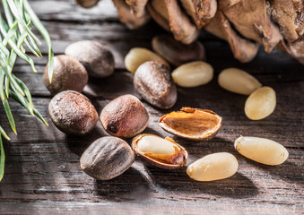 Pine nuts on dark wooden table. Organic food. Macro.