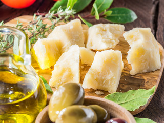 Parmesan cheese on wooden cutting board. Food background.