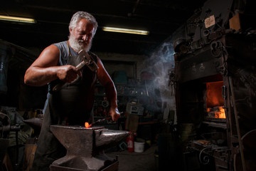 Blacksmith with brush handles the molten metal