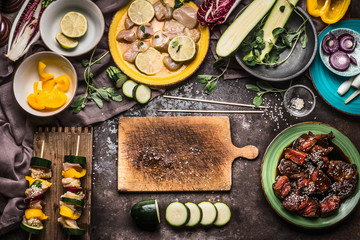 Preparation of various homemade meat vegetables skewers for grill or bbq on rustic background with...