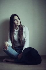 Portrait of a young adult woman in a white shirt thoughtful