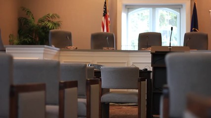 Sitting at the back of the city council room.