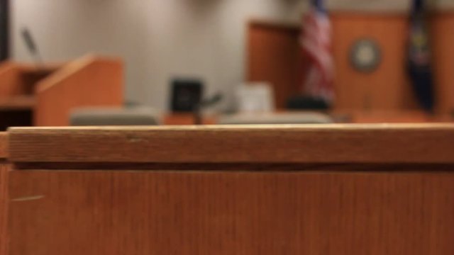 A wooden half door swings in a courtroom.