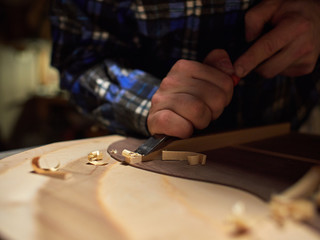 The process of making a classical guitar. Making the right shape of a brace guitar.