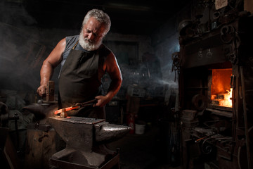 Blacksmith with brush handles the molten metal