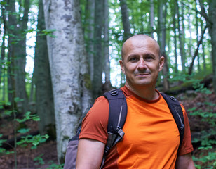 Naklejka na ściany i meble Man with backpack hiking on a trail
