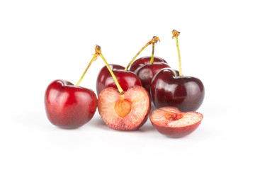 Group of four whole two halves of sweet bright red cherry isolated on white...........................................................................