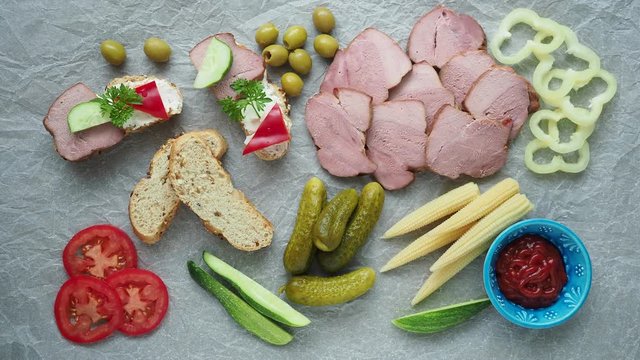 Cold appetizer. Cold cuts. Different snacks on a white crumpled paper, from above.