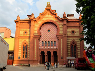 Obraz premium Ukraine, Uzhhorod - April 30, 2018: Uzhgorod Synagogue building or Regional Philharmonic Hall, close-up. Beautiful old red brick building with a mosaic facade