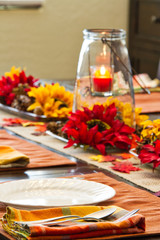 A table set for a fall feast with the focus on the foreground.