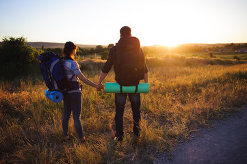 travelers with backpack walking  in sunset