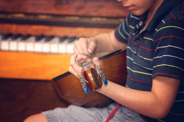 The boy plays the guitar and takes chords, dombra on the background of the piano.