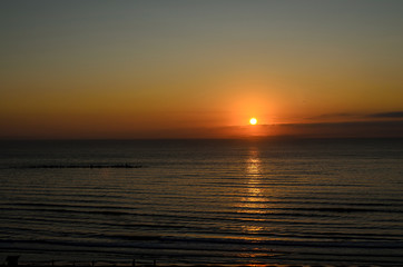 Naklejka premium Beach of Black Sea from Mamaia, Romania with golden orange sky, sands and blue clear water, sunrise