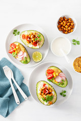 avocado boats stuffed with hummus, tomatoes, radish, roasted chickpea