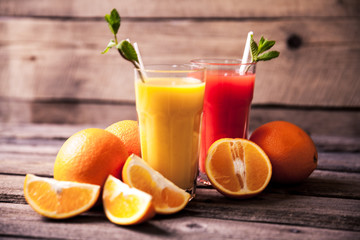 Fototapeta na wymiar Orange juice in glass with mint, fresh fruits on wooden background a
