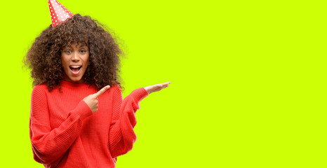 African american woman celebrates birthday very happy pointing with hand and finger