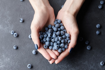 Close up of woman hands holding fresh blueberries. Healthy eating, dieting and vegetarian food...