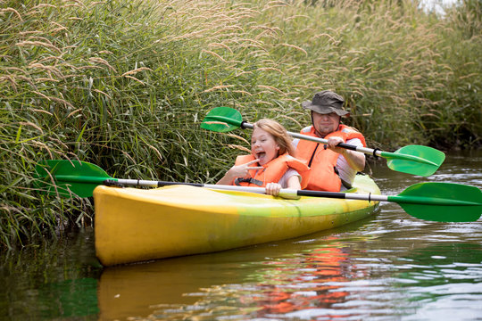 Family kayaking, father and child paddling in kayak
 