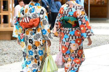 Naklejka premium Young girl wearing Japanese kimono standing in front of Sensoji Temple in Tokyo, Japan. Kimono is a Japanese traditional garment. The word 