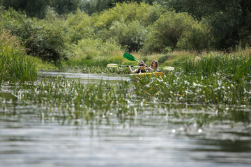 Two happy girls enjoying kayak on the river