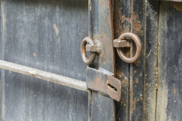 iron door with old opened lock with rusty rings.