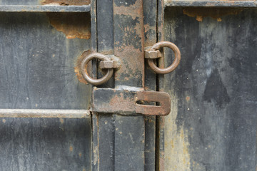 iron door with old opened lock with rusty rings.