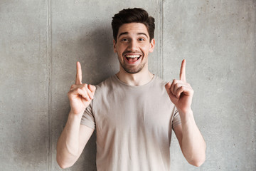 Happy young man pointing to copyspace.