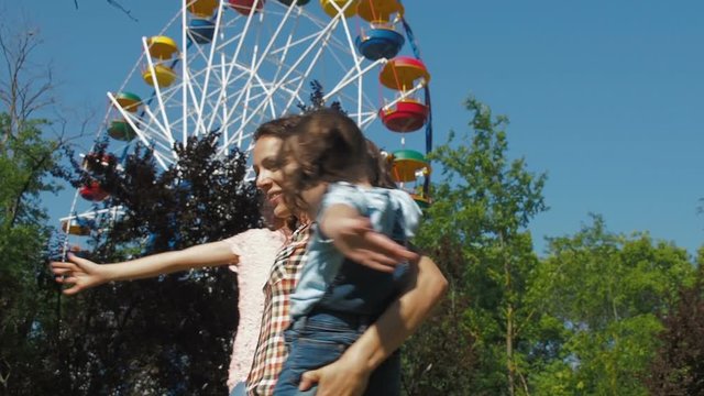 Happy family in the park. A woman in the park plays with the children.