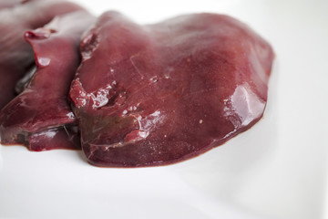 Pieces of fresh raw duck goose liver for paste cooking. Closeup. On white background. Macro shot.